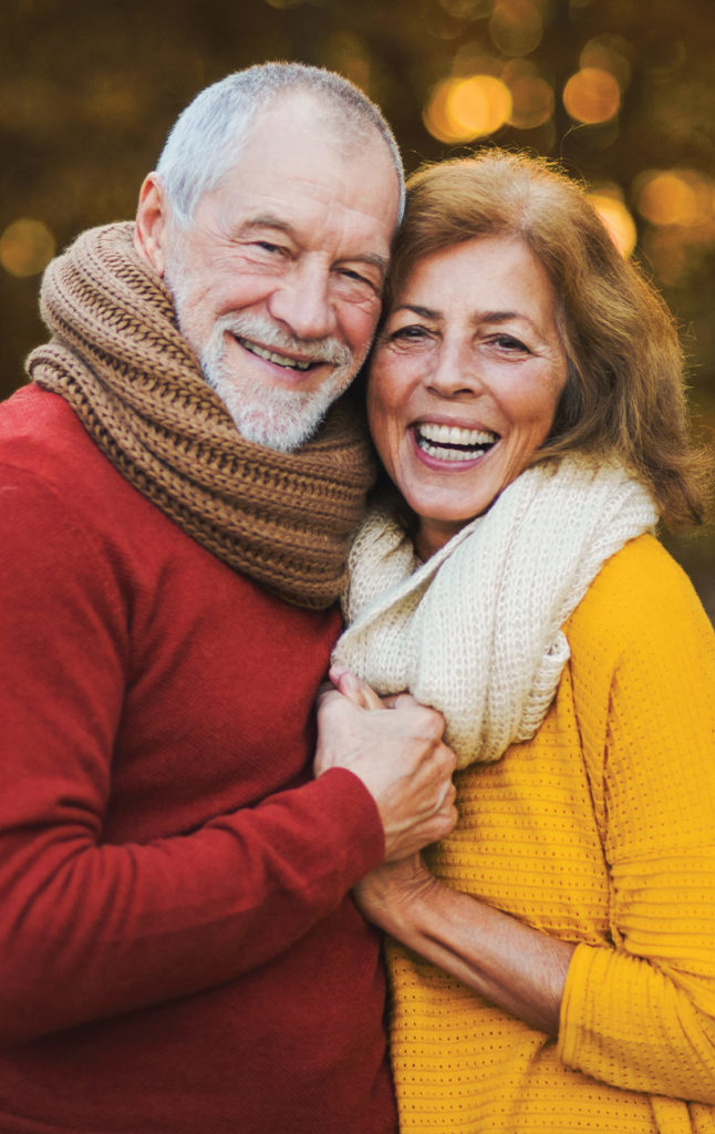 portrait of senior couple smiling at camera with fall foliage in the background successful retirement strategies germantown wi