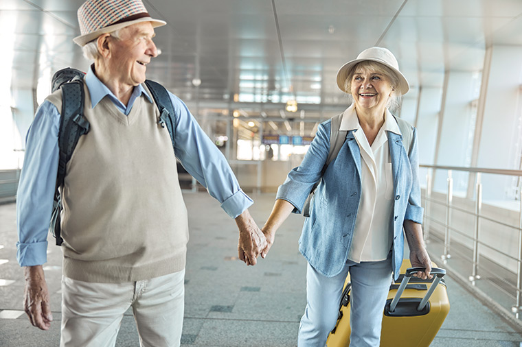 senior couple holding hands at the airport ready for vacation reasonable rate of return with our three core principles germantown wi